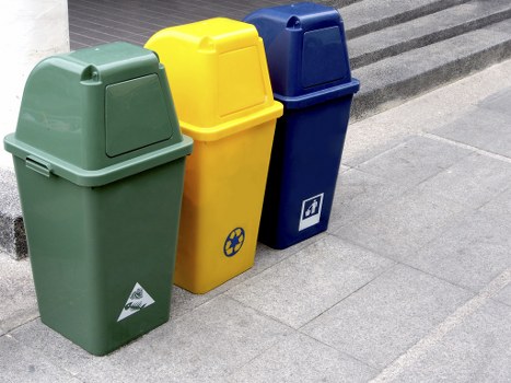 Construction workers unloading waste into a skip on a building site